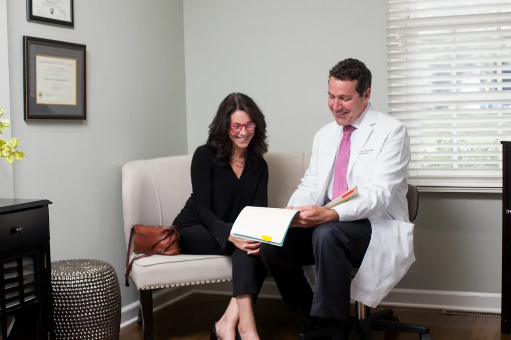 Dr. Nicholas Sieveking reviewing a surgical plan with a patient in his Franklin consultation room.